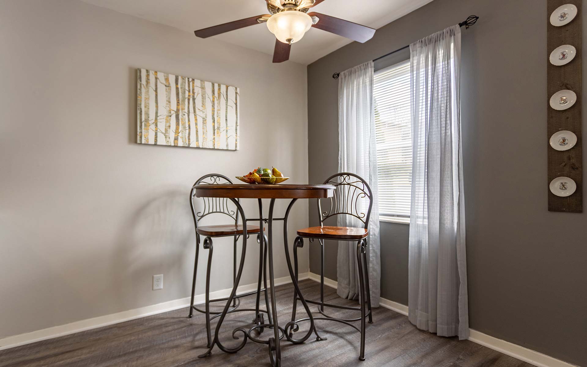 a dining room with a table and chairs and ceiling fan at The Pine Hills